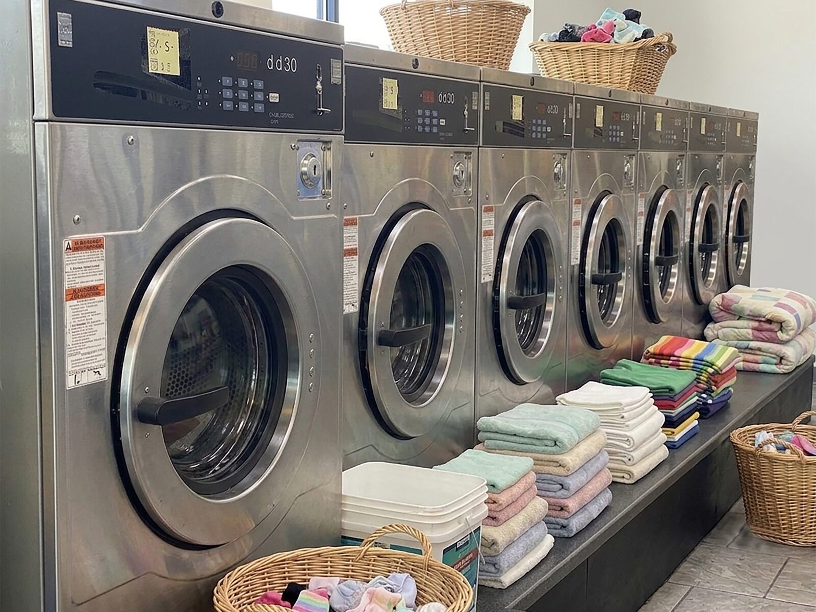 Row of washing machines and folded laundry at Jasmin Express in Barnet